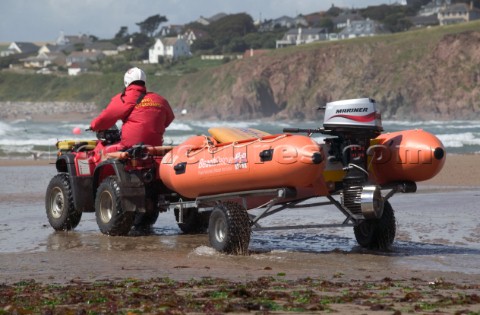 RLNI rescue launch is towed across wet sand at low tide Bantham Devon