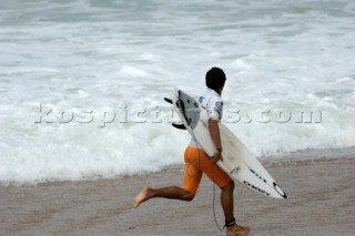 Surfer Adriano de Souza running into surf at the Rip Curl Championship 2005