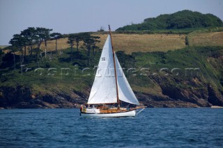 Classic sloop sailing along the Cornish coast, UK