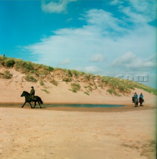 Pony trekking along beach near Aberdeen, Scotland
