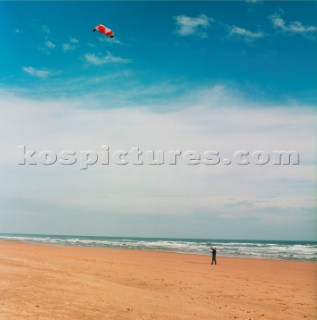 Man kite boarding on flat sandy beach near Aberdeen, Scotland