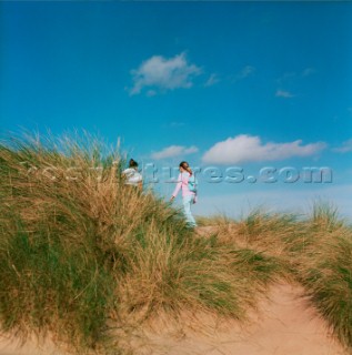 Family walking through sand dunes on beach near Aberdeen