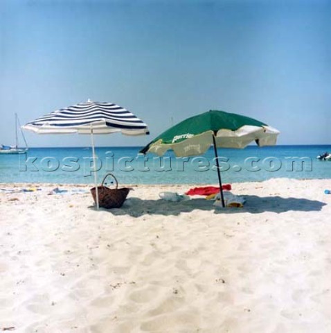 Two parasols on white sandy beach Corsica