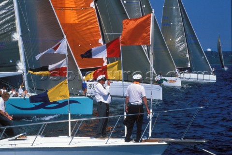 Race officials oversee the start of a yacht race as the fleet cross the startline