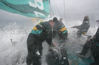 Extreme rough weather sailing shots onboard of the Volvo 70 ABN AMRO surfing downwind with wash, waves and spray on deck testing the teamwork and commitment of the crew
