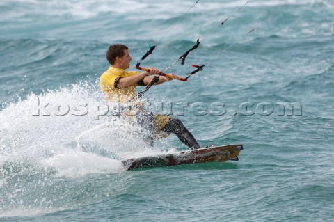 Kitesurfer carving through wave in strong winds
