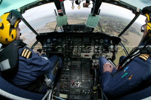 Coastguard Helicopter Cockpit with Pilot and Copilot looking at view over land and sea taken with fi