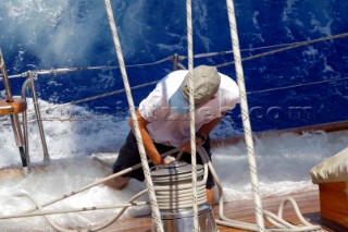 Antigua Classic Yacht Regatta April 2006. Part of sequence of crew member on Aschanti IV working on leeward side as wave comes crashing over side of boat to submerge  him as he holds on to a line