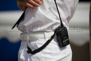 Handheld VHF on the belt of a professional crew of a superyacht whilst on guard duty wearing whites uniform