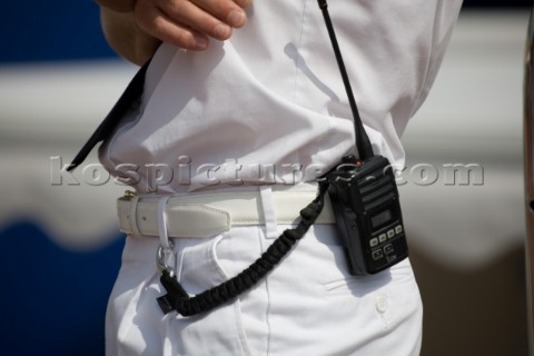 Handheld VHF on the belt of a professional crew of a superyacht whilst on guard duty wearing whites 