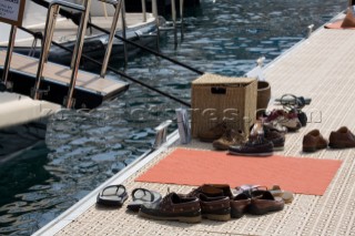 Deck shoes and mat by a superyacht boarding gangway passarelle