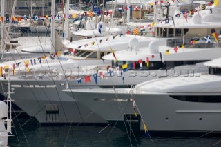 Signal flags and pennants on superyachts and mega yachts dressed overall moored in the busy port of Monaco
