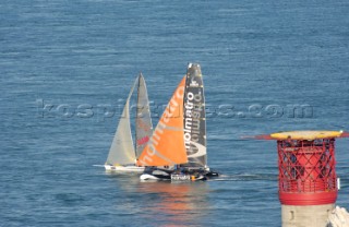 ISLE OF WIGHT, UNITED KINGDOM - JUNE 3:  The Volvo Extreme 40 catamaran Holmatro overtaking the canting keel monohull Full Pelt at the Needles Lighthouse. Holmatro wins line honours as the first yacht to complete the course. Over 1,600 yachts race from the Royal Yacht Squadron startline off Cowes, anticlockwise around the Isle of Wight in the annual JP Morgan Round the Island Race 2006, one of the biggest yacht races in the world.