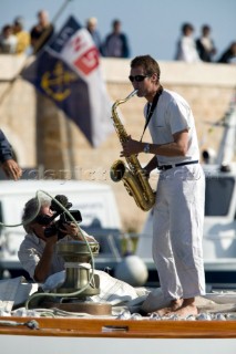 SAINT-TROPEZ, FRANCE -  OCT 5th: Part of the traditional festivities for the Voiles de St Tropez regatta is for crew members to play instruments as the yachts leave harbour. Here the crew man on the classic yacht Marquita built in 1911, plays a brass instrument on the foredeck on October 5th 2006. The largest classic and modern yachts from around the world gather in Saint-Tropez annually for a week of racing and festivities to mark the end of the Mediterranean season, before heading across the Atlantic to winter in the Caribbean.