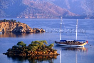 Turkey. Sultans island. A boat sits at anchor in an idyllic setting by an island