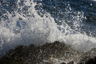 Close up of a wave breaking over the rocks