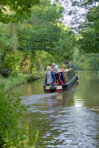 Man and woman on narrowboat having just exited Ellesmere tunnelLlangollen canalEllesmereShropshireEn