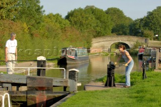 Couple on narrowboat  operating the lock at Wheaton Aston on the Shropshire Union canal,Staffordshire,England,September 2006.