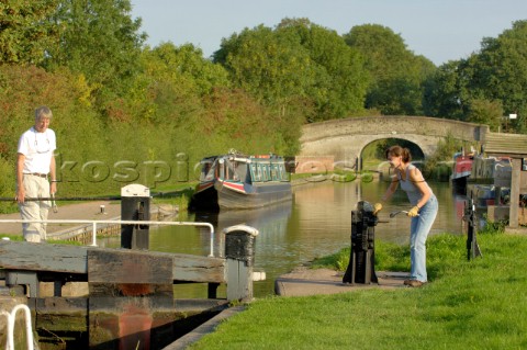 Couple on narrowboat  operating the lock at Wheaton Aston on the Shropshire Union canalStaffordshire