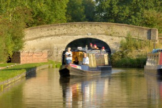 People on narrowboat passing under bridge 18 at Wheaton Aston on the Shropshire Union canal,Staffordshire,England,September 2006.