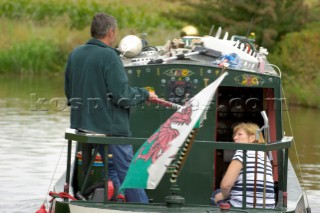 Couple flying the Welsh flag on a  narrow boat on the Llangollen canal at Bettisfield,Clwyd,Wales,September 2006.