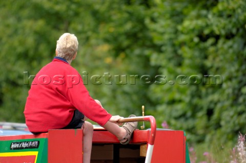Woman driving narrow boat on the Llangollen canal at BettisfieldClwydWalesAugust 2006