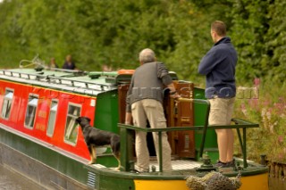 Two men with a dog on narrow boat,Llangollen canal,Bettisfield,Clwyd,Wales,August 2006.