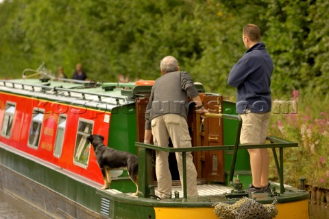 Two men with a dog on narrow boatLlangollen canalBettisfieldClwydWalesAugust 2006
