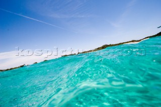 Low level angled view of clear water under a sunny sky just out from the sea shore