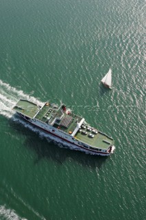 Aerial shot of Red Funnel vehicle and passenger ferry travelling between East Cowes and Southampton with yacht amidships to port