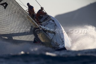 Silhouette of AC yacht in spray and rough water