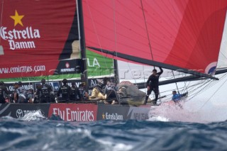 Team New Zealand setting a large red asymmetric spinnaker