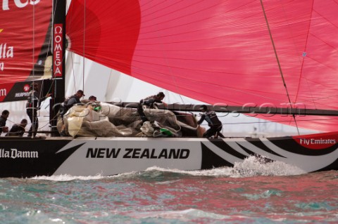 bowmen Richard Meacham crew stow the genoa after NZL84 round the top mark in on the final leg of rac