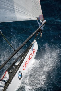 Crew work and teamwork onboard BMW Oracle. Bowman climbs to the end of the spinnaker pole.