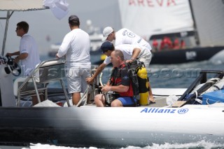 Valencia (Spain) -  Diver prepares to go under BMW Oracle from support boat RIB to clear weed from the keel between races