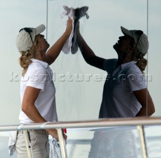 Professional crew cleaning and maintaining a yacht.