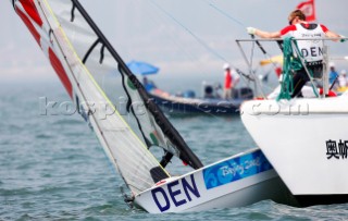 Qingdao, China, 20080809: 2008 OLYMPICS - first day of racing in the Olympic Sailing Event. Martin Kirketerp (DEN) is trying to get his boat off the commitee boat - 49er Class. (no sale to Denmark)