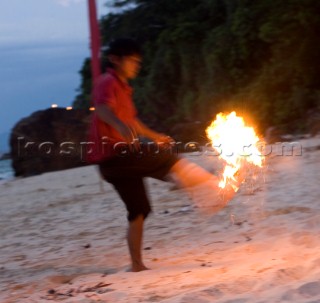 Cruising Malaysia on the tradional yacht Silolona - local game of kicking the flaming coconut on the beach