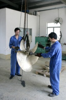 Yacht builders and skilled workers boatbuilding at the Cheoy Lee shipyard and boatbuilders in China. Manufacturing propellers.