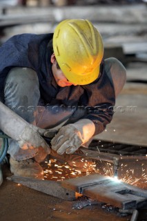 Yacht builders and skilled workers boatbuilding at the Cheoy Lee shipyard and boatbuilders in China. Welders welding.