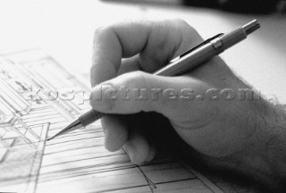 Yacht designer and naval architect at work and drawing board with pencil