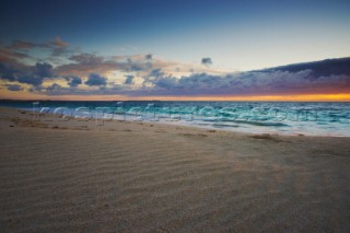 Colourful sunset over a sandy beach.