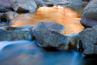 Slow exposure of a colourful stream running over the rocks of an impressive gorge