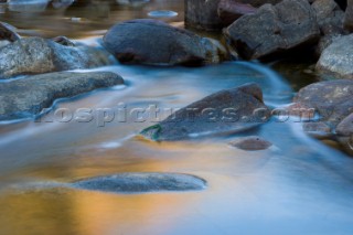 Slow exposure of a colourful stream running over the rocks of an impressive gorge