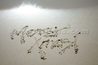 Merry Christmas Xmas sign writing message on a sandy beach in Tarifa, Spain, near Gibraltar.