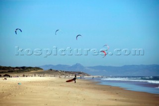 Kite surfer walking on a sandy beach in Tarifa, Spain, near Gibraltar.