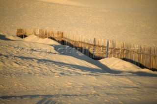 Sand dunes and fencing on a wind swept sandy beach in Tarifa, Spain, near Gibraltar.