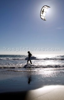 Kite surfer walking on a sandy beach in Tarifa, Spain, near Gibraltar.
