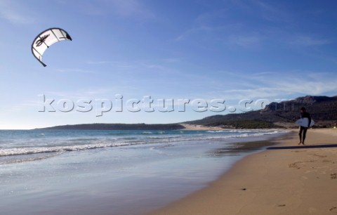 Kite surfer walking on a sandy beach in Tarifa Spain near Gibraltar
