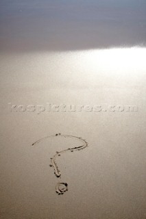 Question mark sign writing message on a sandy beach in Tarifa, Spain, near Gibraltar.